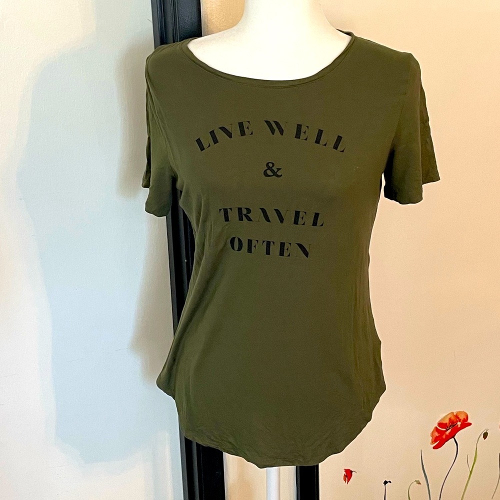Green stretch t-shirt with black print “live well & travel often”